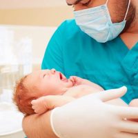 Pediatra cuidando a bebe