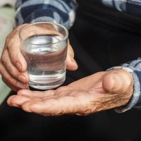 Mano con vaso de agua