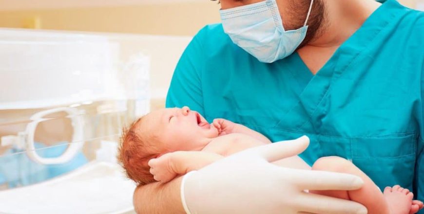 Pediatra cuidando a bebe